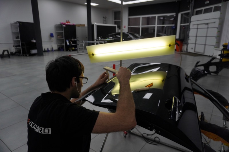 Специалист удаляет пдр вмятину без покраски